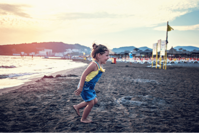 Photo of child running on a beach to illustrate using a fast shutter speed.