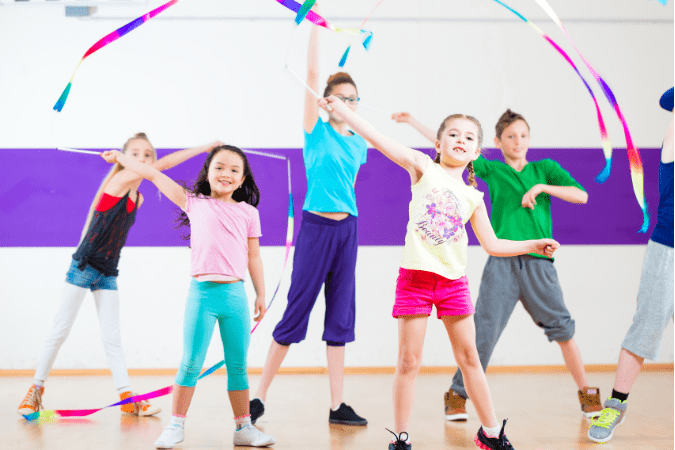 Photo of a group of children twirling ribbons in the air to illustrate your camera's autofocus tracking feature.