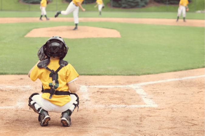 Photo of a child playing the catcher in a baseball game to illustrate the rule of thirds.