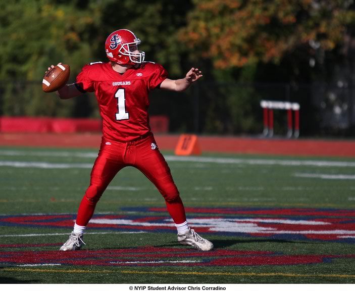 A wide aperture of f2.8 was used to focus attention on the Quarterback while blurring
the background. The bright red uniform contrasts nicely with the fall foliage in the background and the green
of the field.