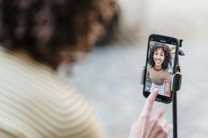 Girl using tripod and self-timer to take a selfie.